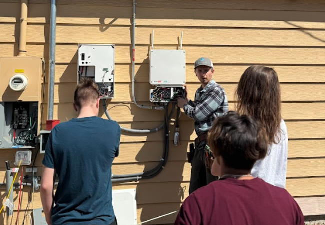 Apollo Energy installer walking trade students through a solar inverter install